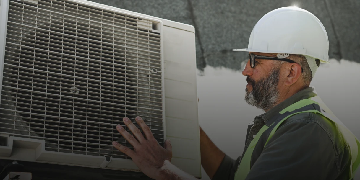 Worker inspecting air conditioning unit